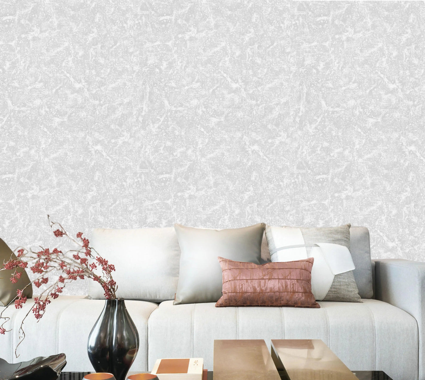 Living room with a gray sofa, decorative pillows, and a vase against a patterned wall.