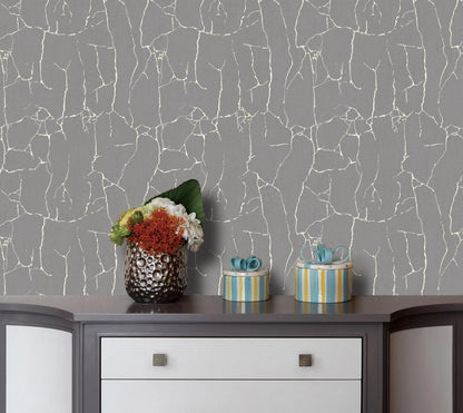 Decorative items on a shelf against a gray wall with white crackle pattern