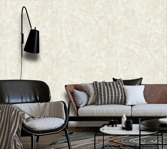 Modern living room with a sofa, chair, and wall lamp against a textured white wall.