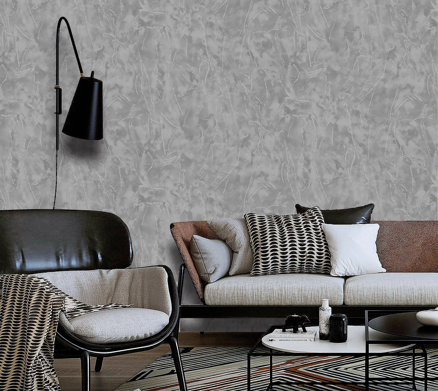 Modern living room with a gray textured wall, brown sofa, and black armchair.
